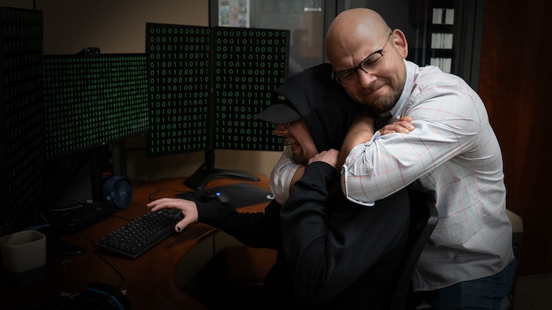 Daniel Ruiz, Point of Rental's cybersecurity expert, puts a hacker in a headlock at his desk.
